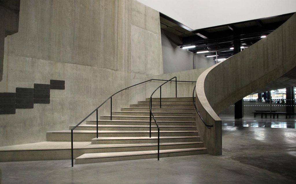 Moderne betonlook gietvloer met industriële look in een stijlvol interieur met natuurlijke lichtinval
