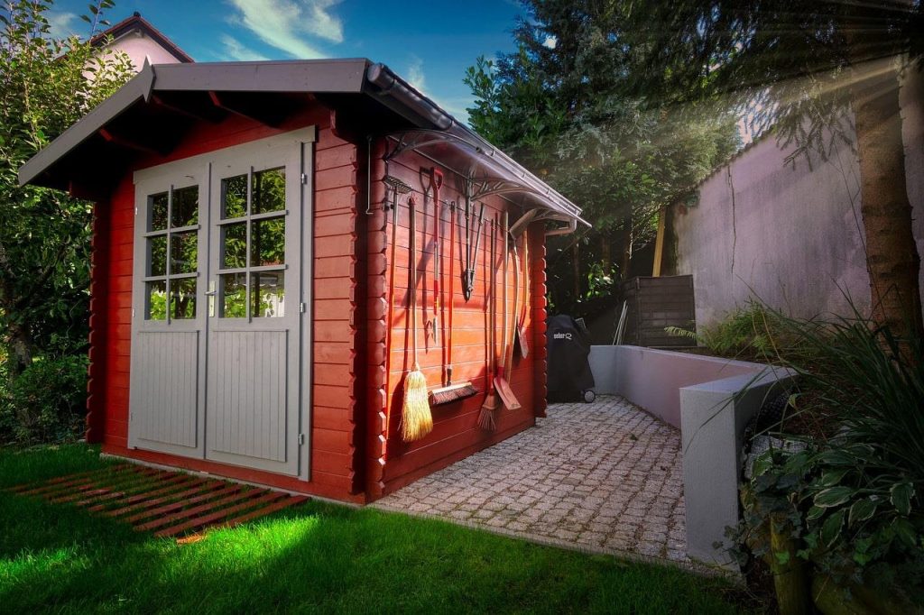 Houten blokhut met veranda in een groene tuin, biedt extra ruimte en ontspanning buiten